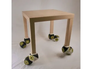 Mesa experimental equipada con módulos Roombots en sus cuatro patas, publicada por EPFL BioRob.