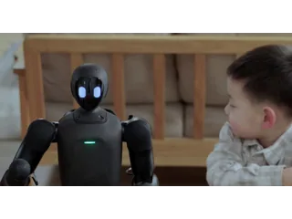 Imagen oficial de un PrimeBOT Q1 negro con los ojos iluminados, sentado junto a un niño en un banco.