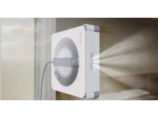 Render oficial del WINBOT W2S Pro Omni adherido a un cristal, con su cable conectado y los pulverizadores laterales en funcionamiento.
