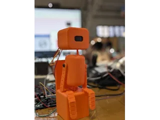 Fotografía del equipo Posture Pet del robot completo, con cuerpo de bloques naranjas, articulaciones y cara OLED.