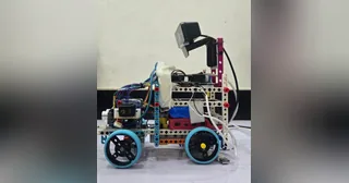 Fotografía de The Statesmen de su coche robot completo, con chasis LEGO, cuatro ruedas y soporte elevado de cámara; recorte de la fotografía original.