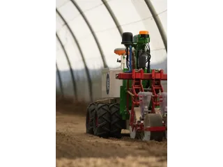 Robot Naïo Oz con un apero en un invernadero.