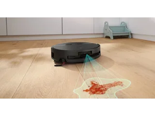 Render promocional del Spotless 2 Advanced+ negro sobre suelo de madera, con un gráfico de detección de manchas.