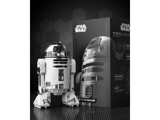 R2-D2 de Sphero fotografiado junto a su caja, con cabeza y tres apoyos visibles.