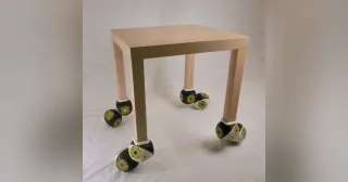 Mesa experimental equipada con módulos Roombots en sus cuatro patas, publicada por EPFL BioRob.