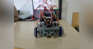 Fotografía de CYBERRCORE del vehículo completo visto de frente, con ultrasonidos, dirección y cableado sobre el chasis.