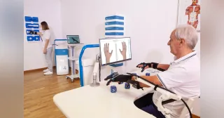 Sistema Gloreha Sinfonia con guante robótico en una sesión mostrada por el fabricante.