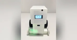 Fotografía del equipo Jarvis de su robot completo, con carcasa blanca, cara en pantalla, dos ruedas negras y ruedas auxiliares claras.