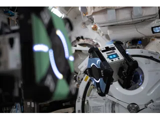 Un robot cúbico Astrobee fotografiado dentro de la Estación Espacial Internacional.