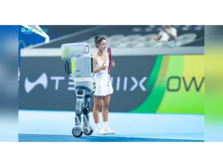 Fotografía oficial del robot de tenis TENNIIX ULTRA MAX junto a Wang Qiang en la pista de la Billie Jean King Cup.
