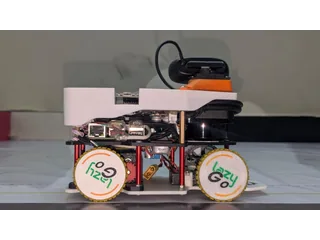 Fotografía del equipo LazyGo de LazyBot completo visto de lado, con cuatro ruedas, lidar y cámara sobre un soporte orientable.