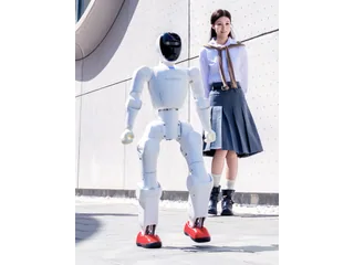 Humanoide Noetix Bumi caminando delante de una persona en una fotografía oficial