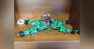 Fotografía de OriginalGoodUsername del robot híbrido completo, con cuerpo verde, cuatro patas articuladas y ruedas en los extremos.