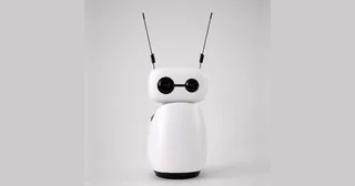 Fotografía oficial de Reachy Mini Wireless blanco visto de frente, con sus dos antenas negras y la base completa sobre un fondo gris claro.