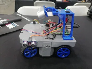 Fotografía del Equipo Octobots de Octoneer completo, con cuerpo gris, cuatro ruedas azules y un soporte elevado de componentes.