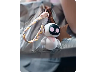 Fotografía oficial de un Eiliko blanco y rosa sujeto a una mochila gris.
