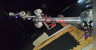 Prototipo del brazo espacial Manus de Redwire, con estructura metálica y cableado, extendido durante una prueba en laboratorio.