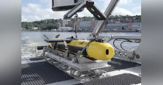 Sistema submarino KATFISH amarillo apoyado en su equipo de lanzamiento y recuperación sobre la cubierta de un barco.
