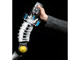 Bionic Handling Assistant completo, sostenido con una mano y sujetando una pelota junto a la trompa de un elefante.