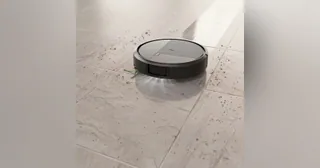 Fotografía promocional oficial de Roomba Plus 575 Combo completo aspirando sobre un suelo claro, publicada por iRobot.
