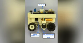 Fotografía del equipo ANTi de su coche robot completo en miniatura, con chasis claro y anotaciones sobre los sensores.