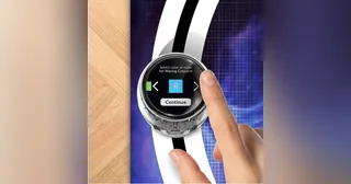 Una mano toca la pantalla circular de Ozobot Ari colocado sobre una pista de códigos de color