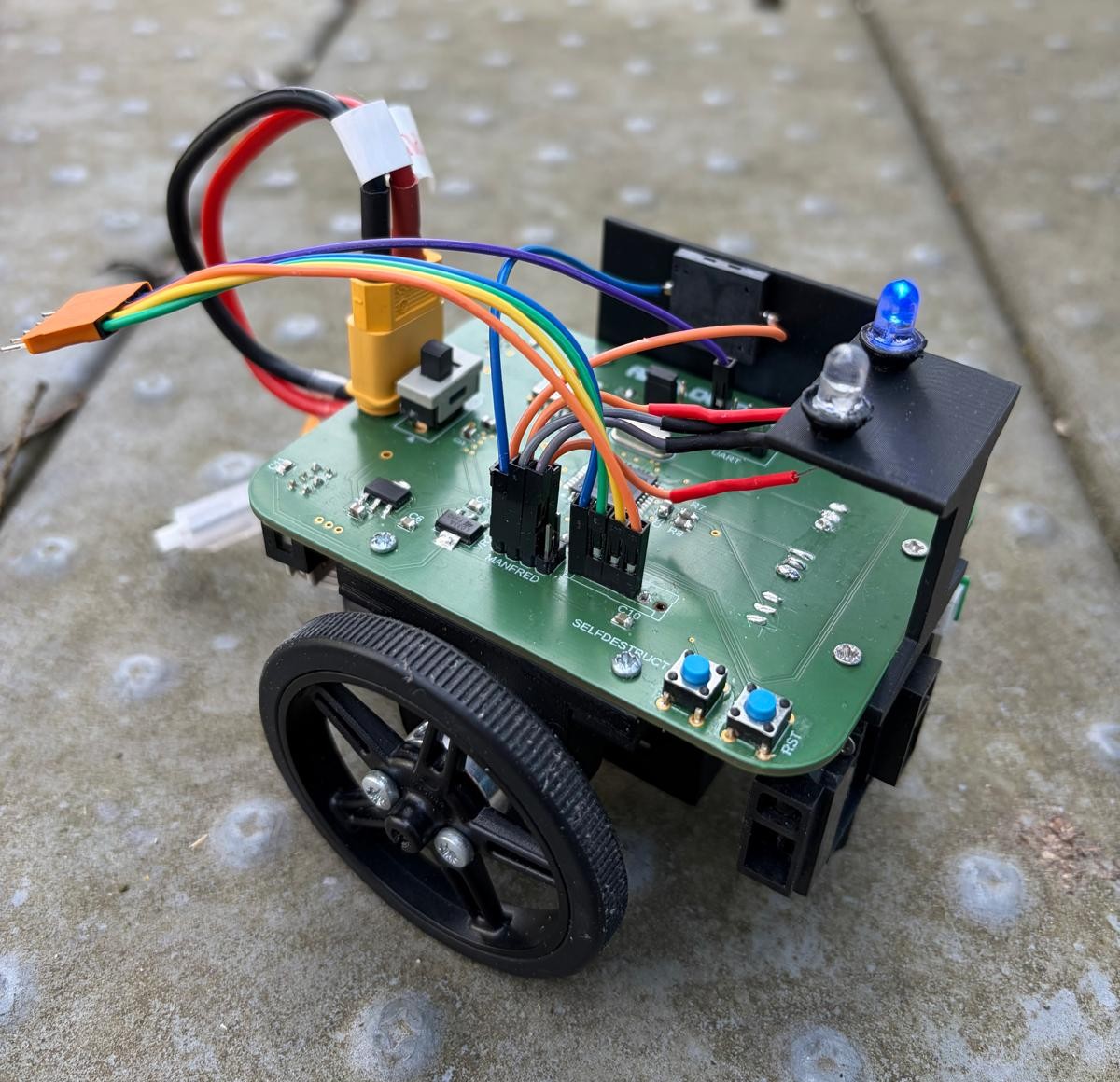 Recorte de una fotografía del equipo de Airflow Don, con placa verde, ruedas, sensores y cableado sobre el cuerpo.