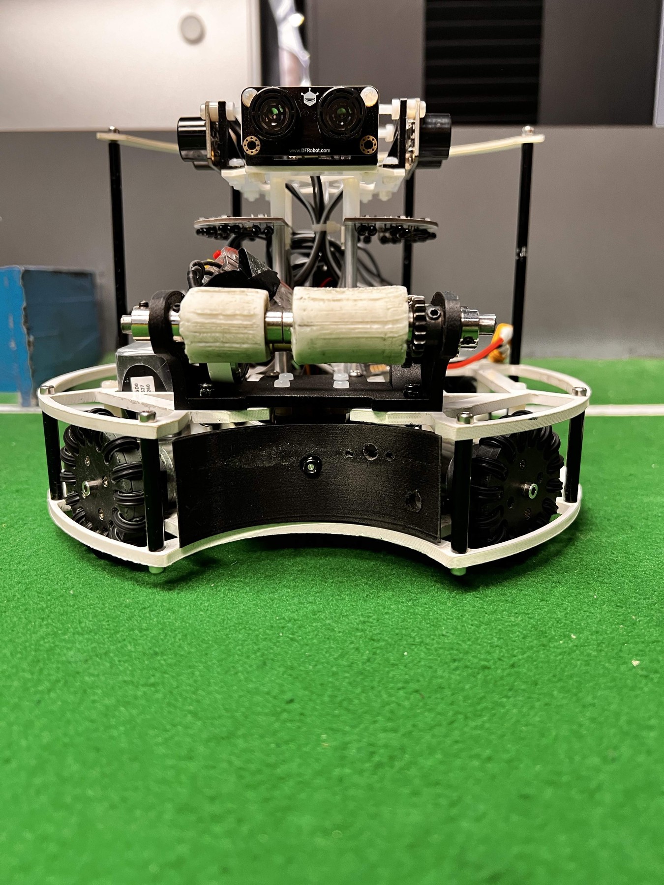 Fotografía del equipo Apex del robot completo, con cuatro ruedas omnidireccionales, retenedor frontal y sensores elevados.