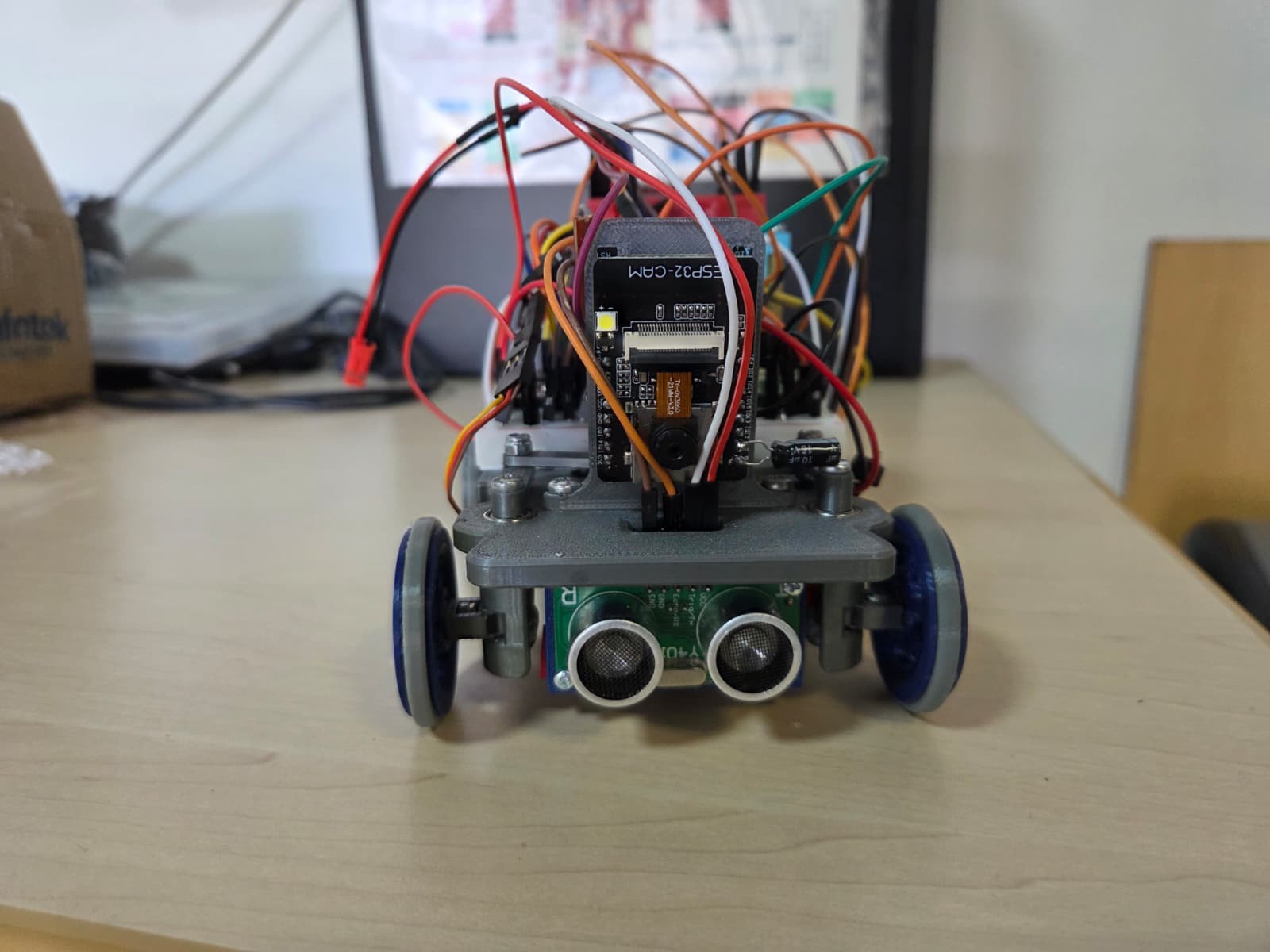 Fotografía de CYBERRCORE del vehículo completo visto de frente, con ultrasonidos, dirección y cableado sobre el chasis.