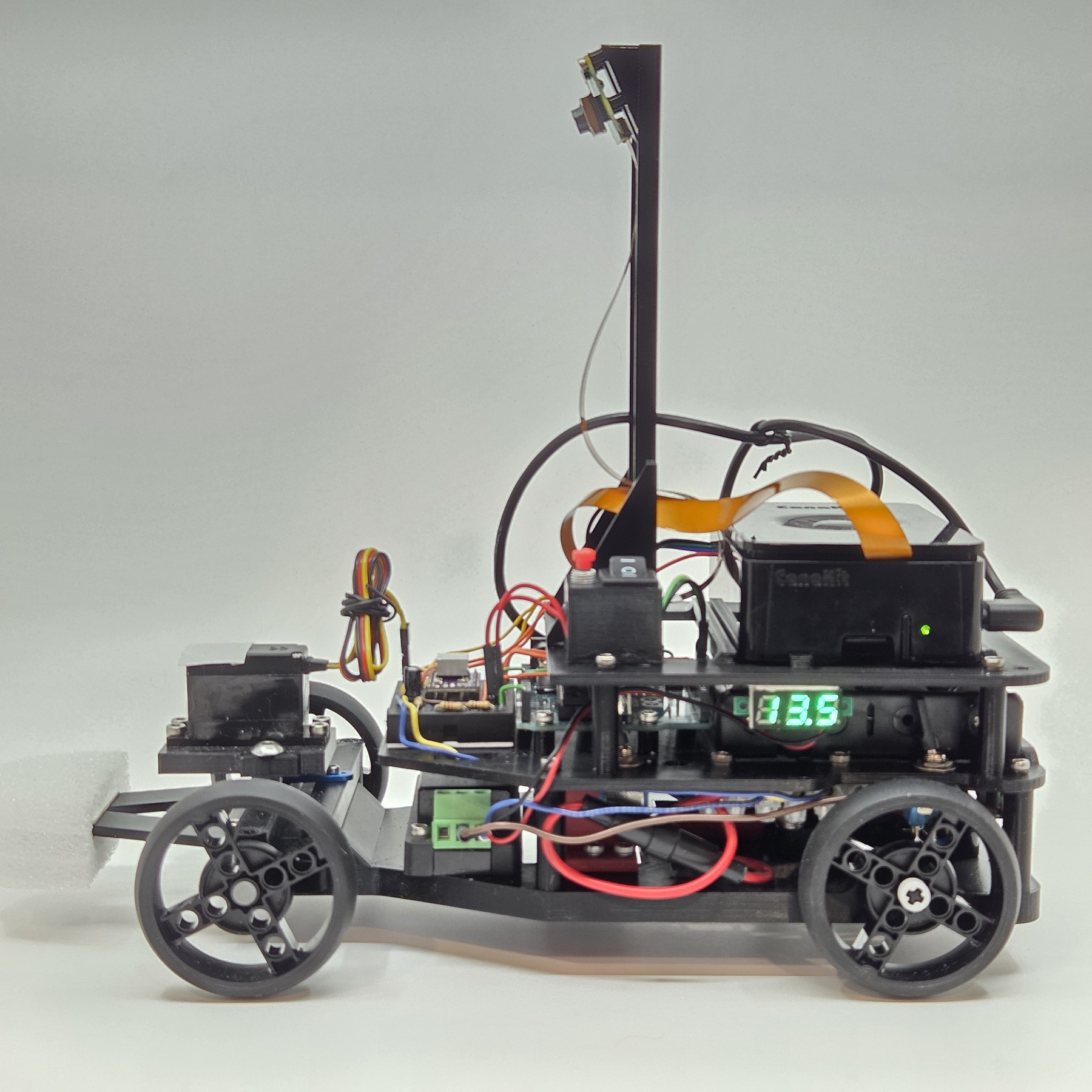 Fotografía de Double-X de su coche robot completo visto de lado, con estructura de tres niveles y cámara en un soporte alto.