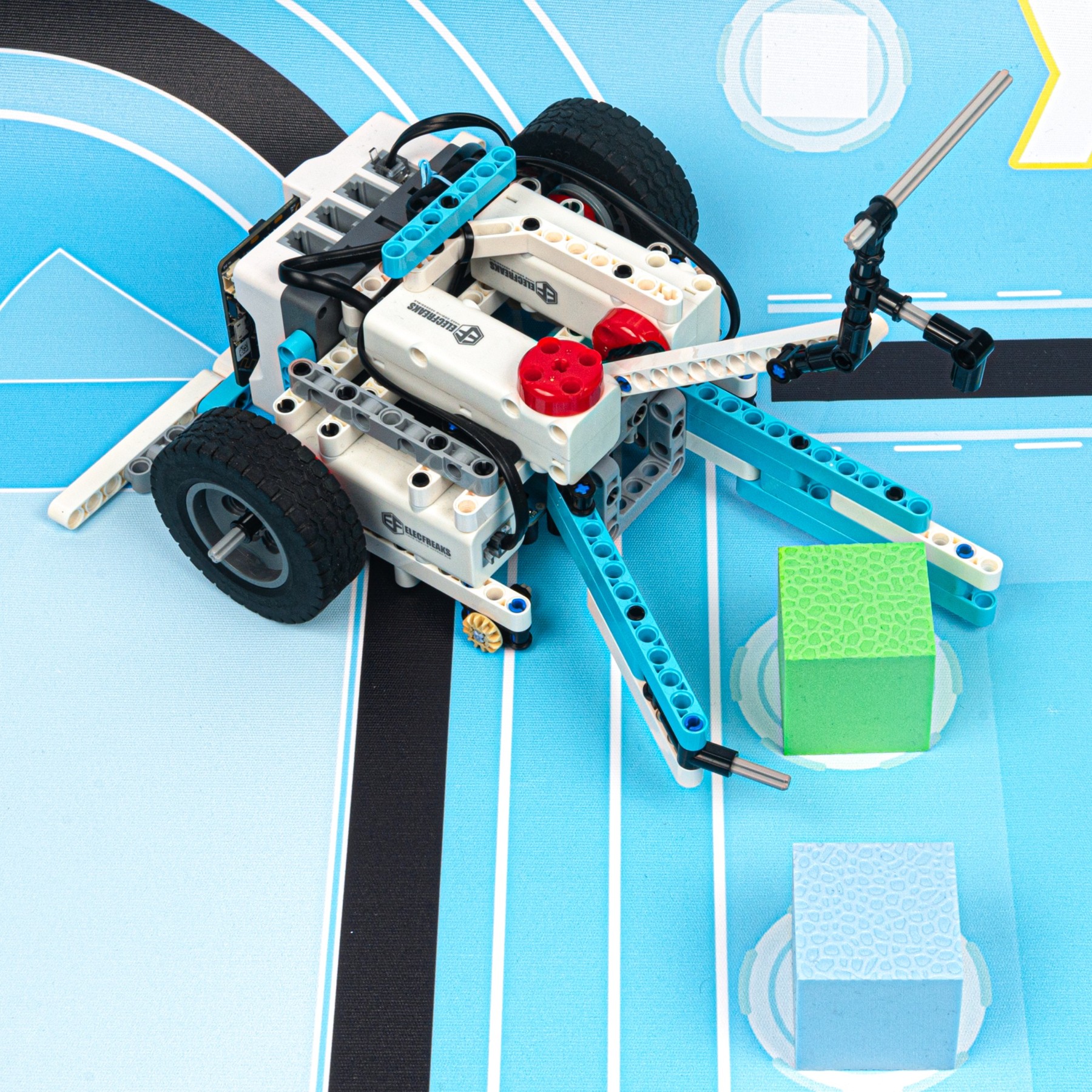 Robot con ruedas construido con Nezha Pro Sports Kit, sobre una pista de seguimiento de líneas.