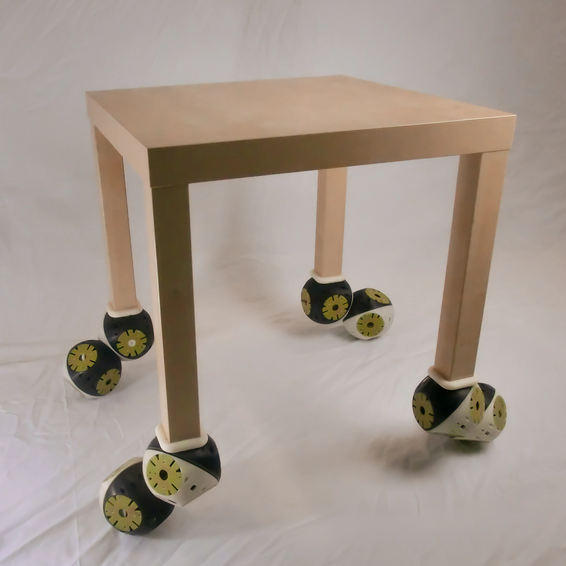 Mesa experimental equipada con módulos Roombots en sus cuatro patas, publicada por EPFL BioRob.
