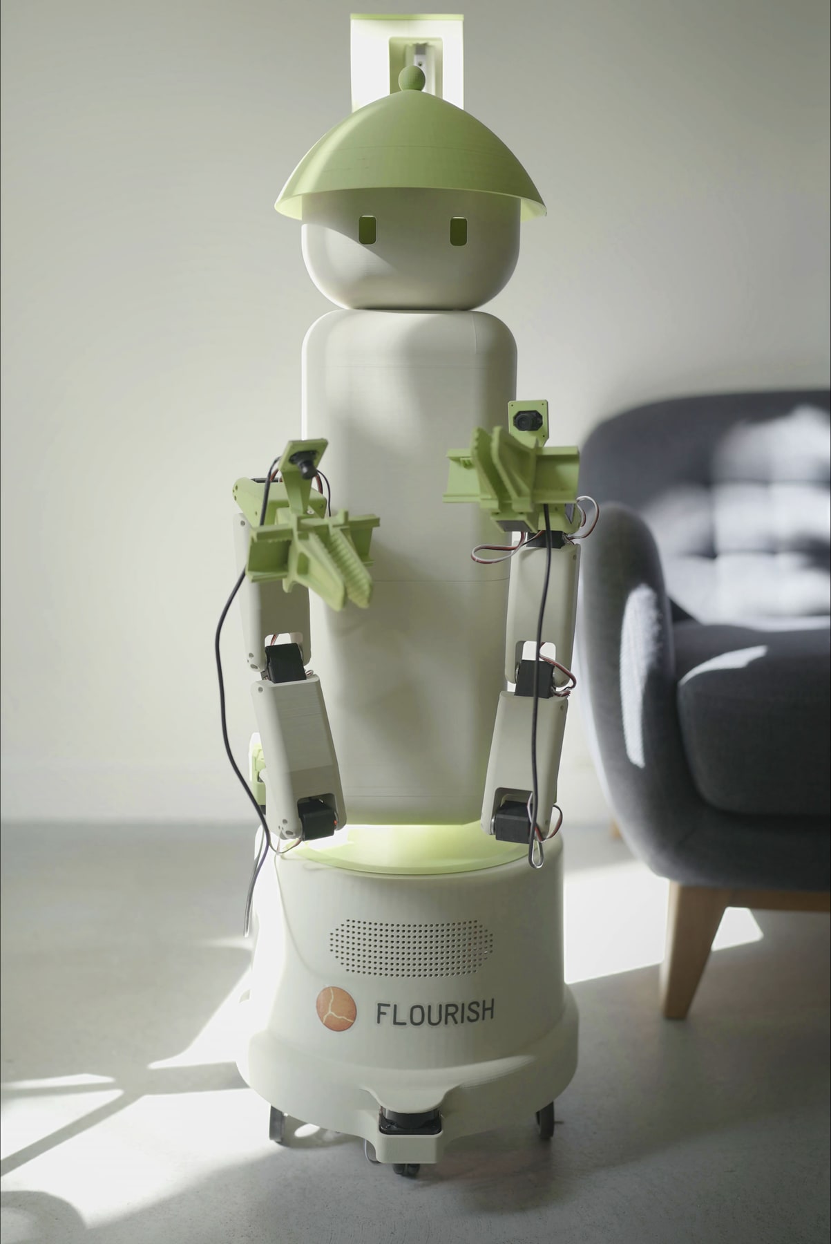 Fotografía oficial de Flourish 1 completo, con cuerpo blanco y verde, manipulador frontal y base de ruedas.