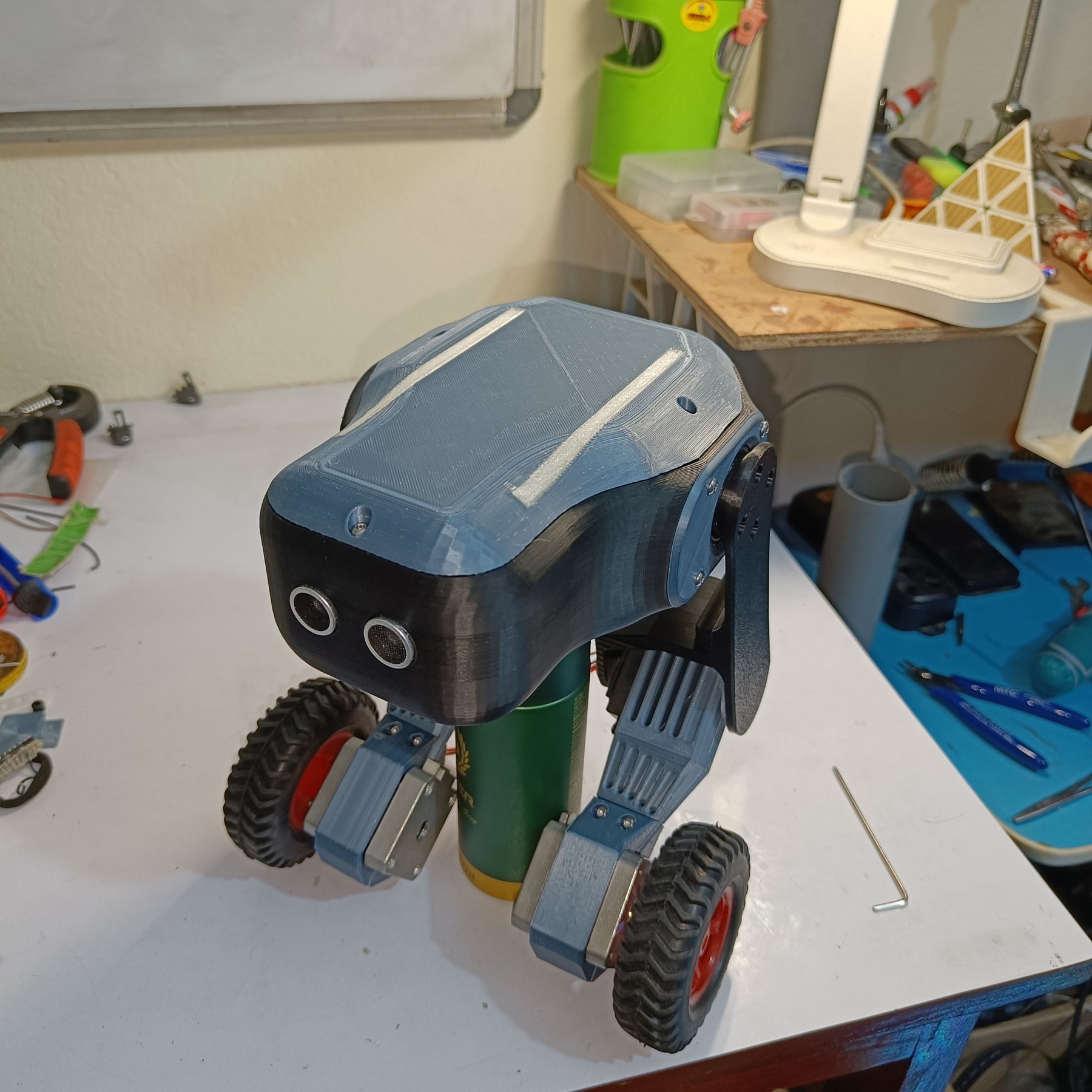 Fotografía de kairobyte del robot completo ensamblado, con dos patas y ruedas, apoyado sobre el banco de trabajo.