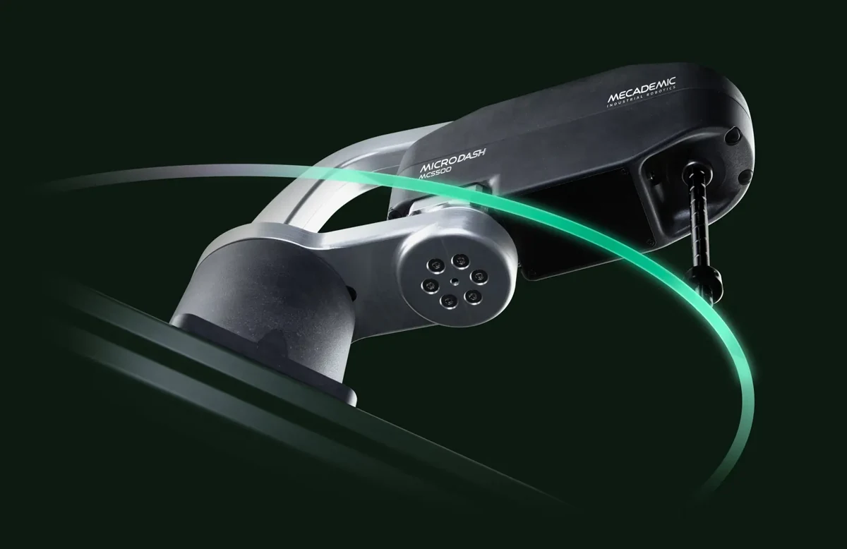 Imagen oficial del robot SCARA compacto Mecademic MCS500, con brazos negros y herramienta vertical, sobre fondo oscuro.