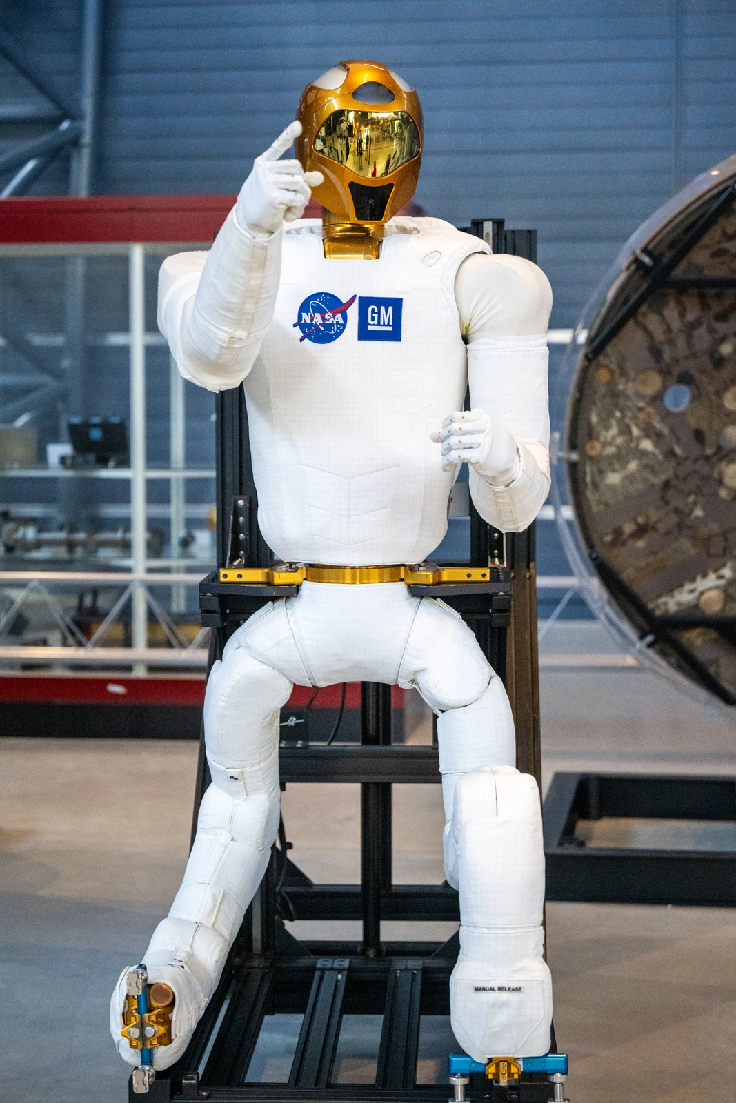 Robonaut 2 completo en un soporte de exposición, con cabeza, torso, ambos brazos y sus dos miembros de movilidad visibles.