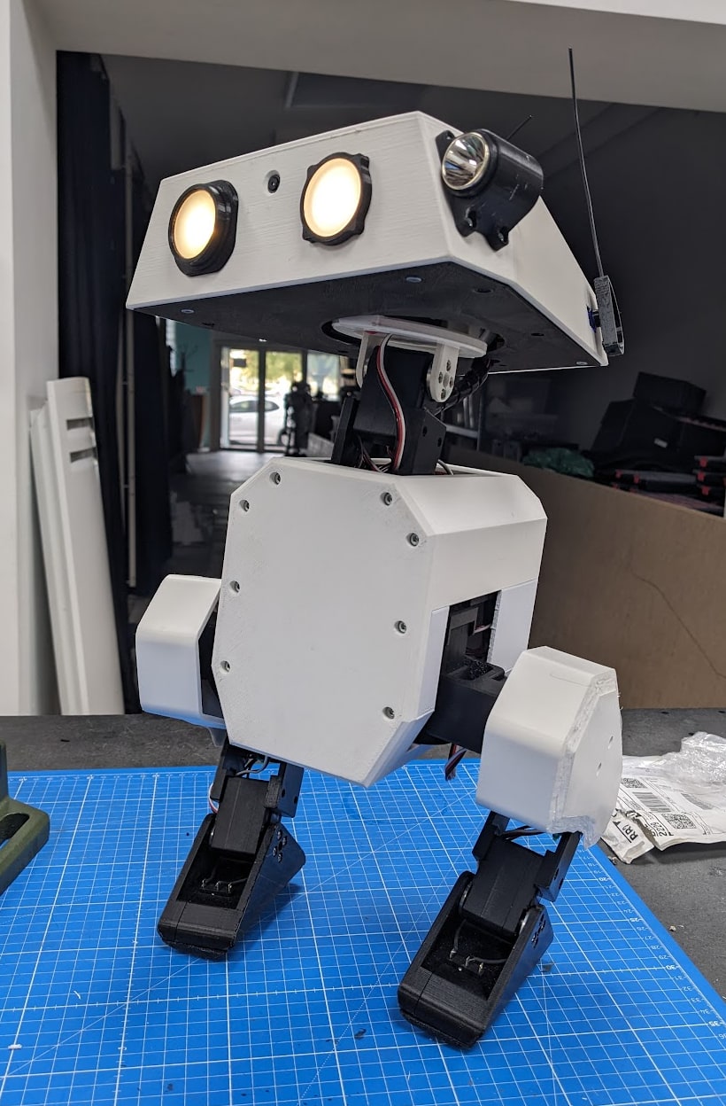 Fotografía del proyecto Open Duck Mini v2 completo sobre una mesa de trabajo, con dos patas y ojos iluminados.
