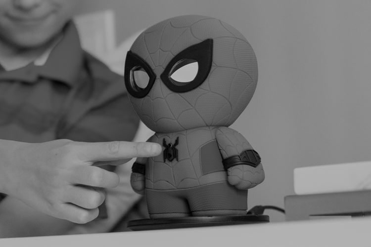 Fotografía oficial en blanco y negro del Spider-Man interactivo de Sphero mientras una persona pulsa su botón frontal.