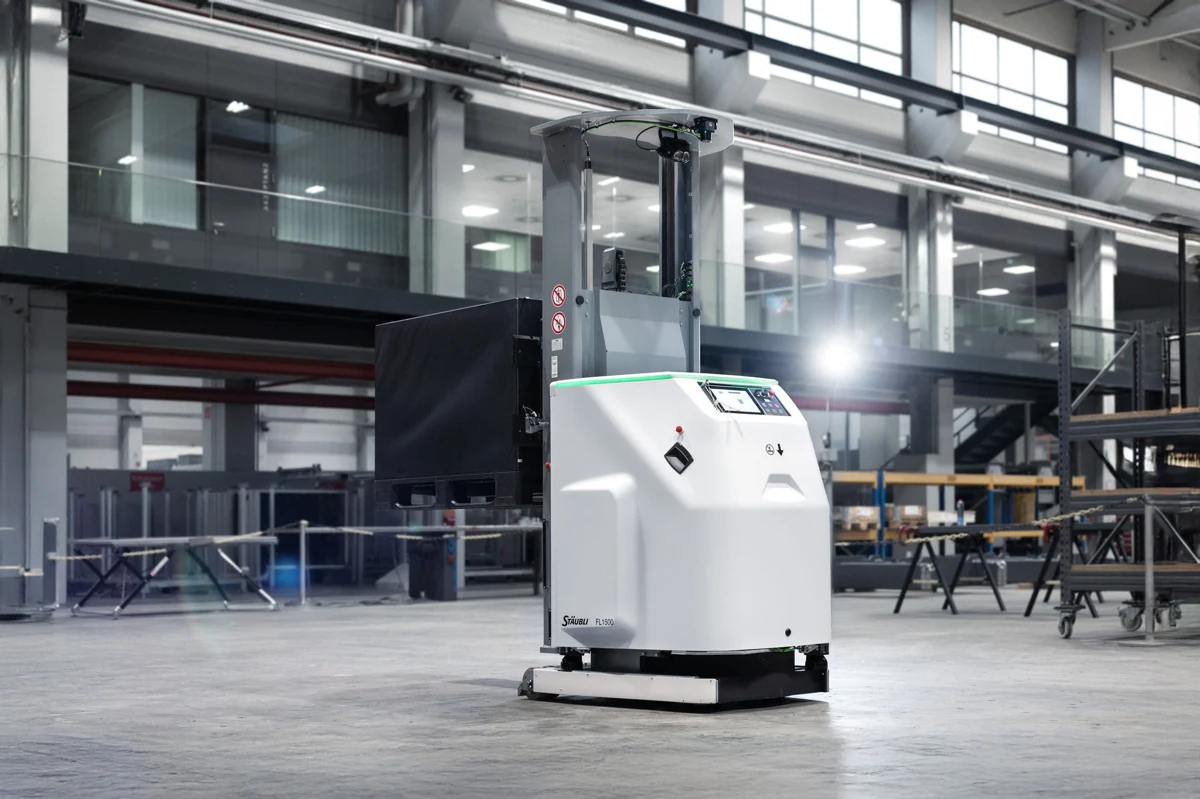 Carretilla autónoma Stäubli FL1500 blanca y negra en una nave industrial, vista desde delante y un lateral.