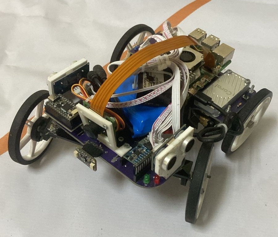 Fotografía de The Pythons de su coche robot completo, con placa estructural, cuatro ruedas y soporte elevado de cámara.