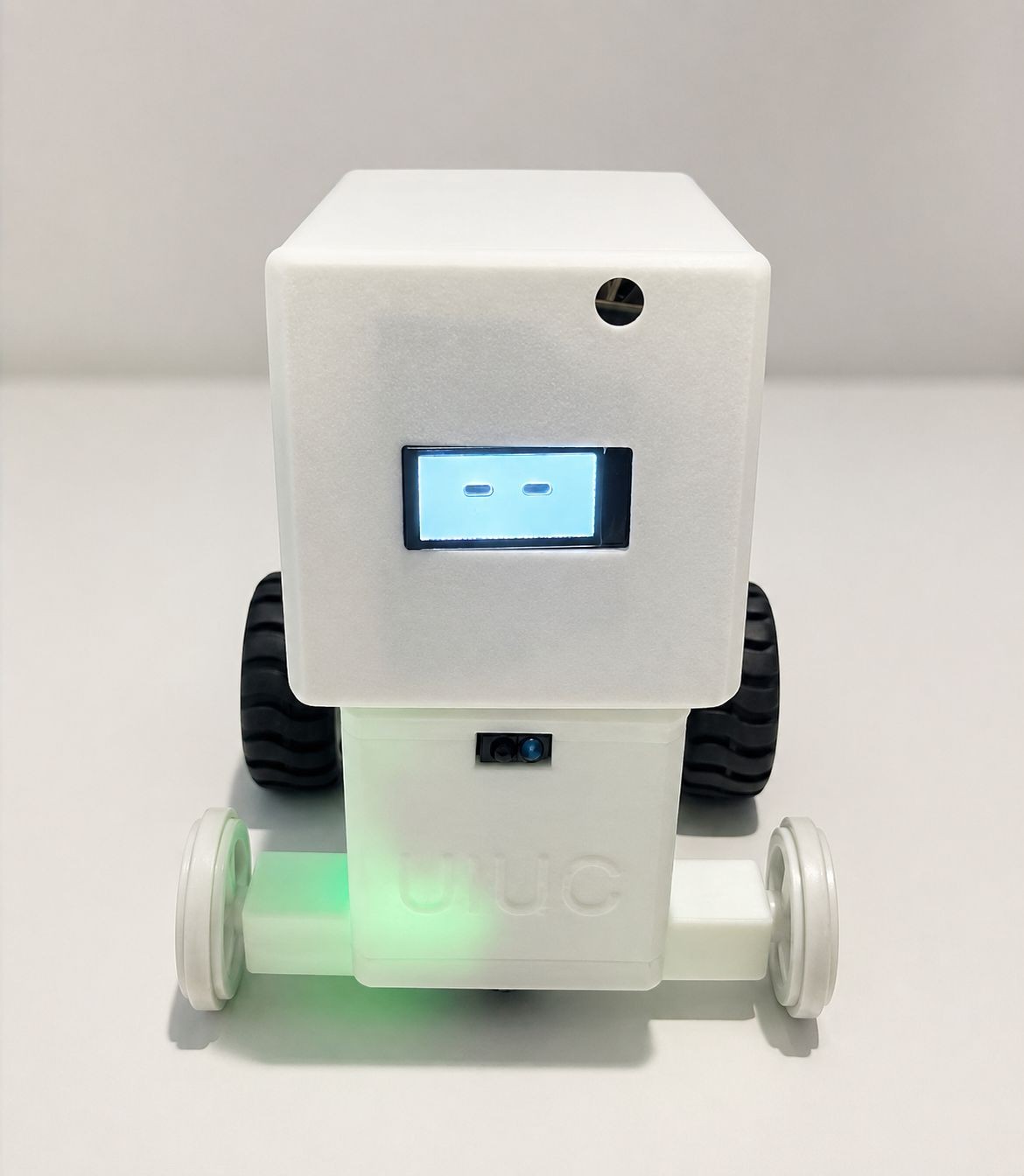 Fotografía del equipo Jarvis de su robot completo, con carcasa blanca, cara en pantalla, dos ruedas negras y ruedas auxiliares claras.