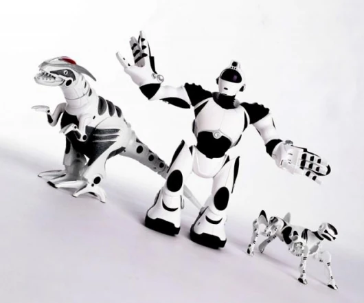 Robosapien V2 en el centro de una fotografía de producto de WowWee, entre Roboraptor y Robopet.